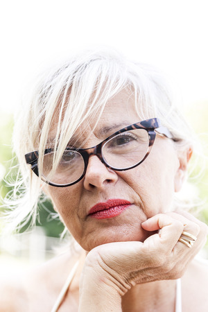 Charming woman in swimsuit posing in the nature of a park in summer. Concept of beautiful people having fun in summertimeの写真素材