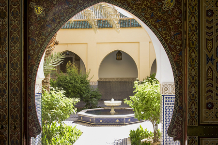 patio with fountain in modern Arab palace with arabesques on arched door