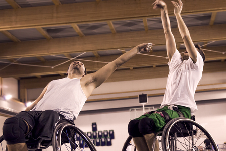 disabled sport men in action while playing indoor basketball at a basketball courtの写真素材