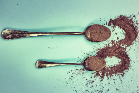 cocoa powder and chocolate pieces on a light blue background with accessories and vintage teaspoons. food conceptの写真素材