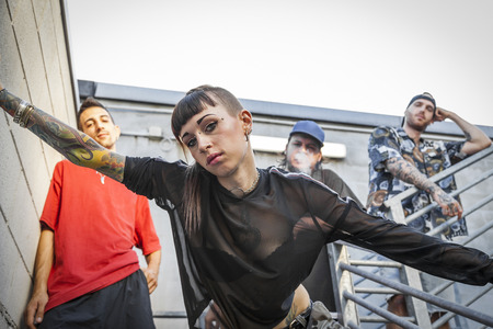 group of rappers posing on the metal stairs of an abandoned buildingの写真素材