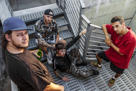 group of young rappers posing on the metal stairs of an abandoned buildingの写真素材