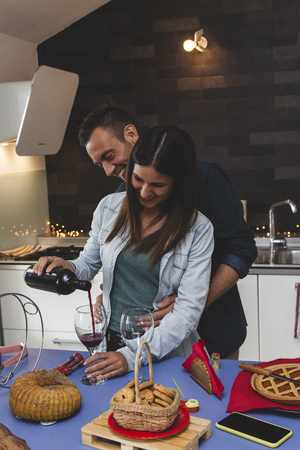 young couple of lovers celebrating at home drinking wine intimatelyの写真素材
