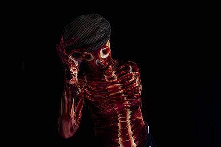 sensual woman dressed in a skeleton costume greets by raising her hat. halloween concept