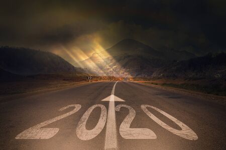 2020 New Year celebration on the asphalt road with the sunbeam coming out of the clouds. New Year arrival conceptの写真素材