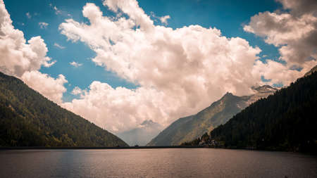 view of a beautiful lake surrounded by the dolomites mountain range in summertimeの写真素材