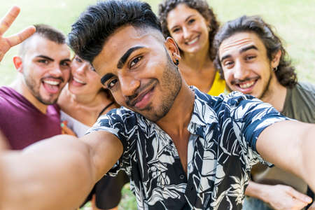 multiethnic group of millennial friends take a selfie outdoors