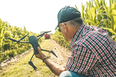 modern technological farmer as he prepares to fly the drone over his cultivated fields. concept of...