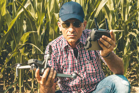 modern technological farmer as he prepares to fly the drone over his cultivated fields. concept of...