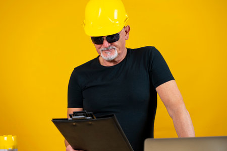 worker is planning the business with computer and phone in a spartan office isolated on yellow...