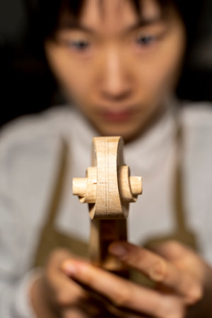 young Chinese violin maker at work in her workshopの写真素材