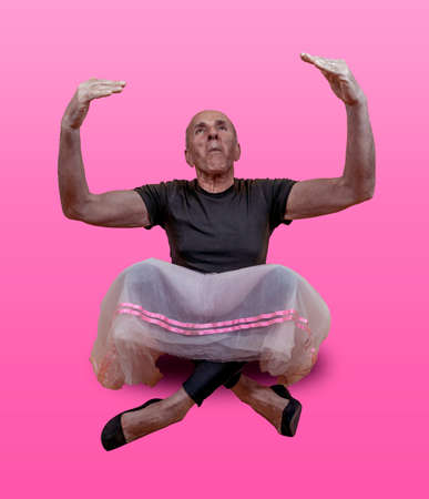 funny portrait of male ballet dancer. A mature ballet dancer dressed in tutu is dancing clumsily on colorful backgroundの写真素材