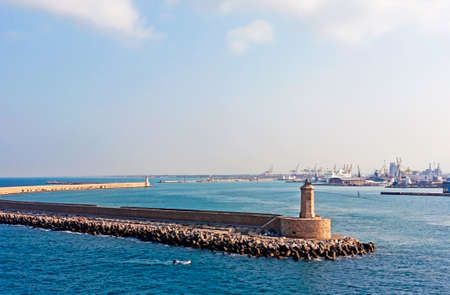 breakwater in front of an industrial port of the mediterranean seaの写真素材