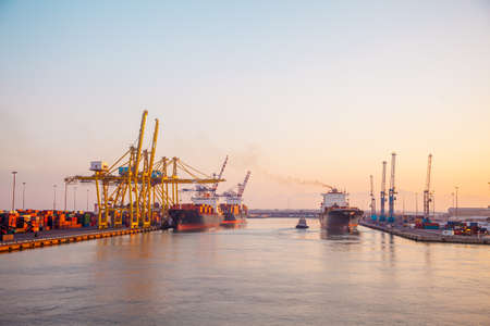 panoramic of an industrial port on the mediterranean sea at sunrise with crane and shipの写真素材
