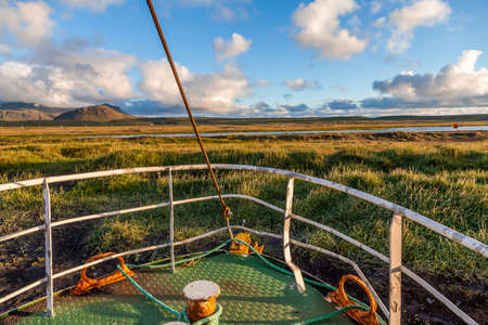 authentic old fisherman boat wrecked on an Icelandic beach under the midnight sunの写真素材
