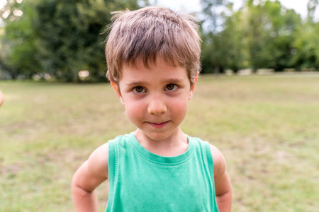 portrait of cute smiling boy in a public park