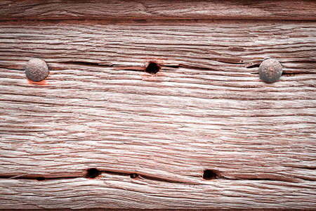 close-up of a rotten wood panel with holes and studs for use as a backgroundの写真素材