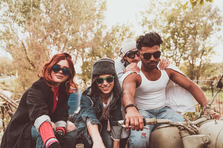 group of best friends together have fun riding a vintage motorcycle with sidecar - Happy friendship conceptの写真素材