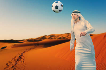 arab businessman playing with a soccer ball in the desert - Concept of the world championships in Qatar 2022の写真素材