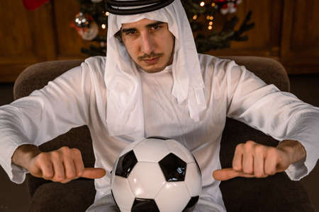 portrait of arab businessman showing a soccer ball in front of lights - Concept of the world championships in Qatar 2022の写真素材