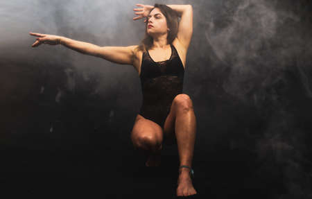 young attractive woman practicing yoga discipline in a foggy room - health and wellness conceptの写真素材