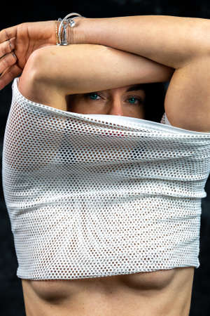 portrait of beautiful woman wearing white t-shirt on black background - studio shotの写真素材