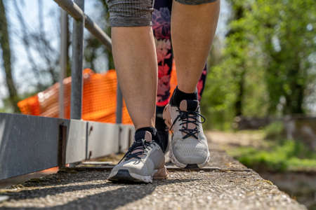 women running on a concrete bridge wearing sportswear - healthy lifestyle conceptの写真素材