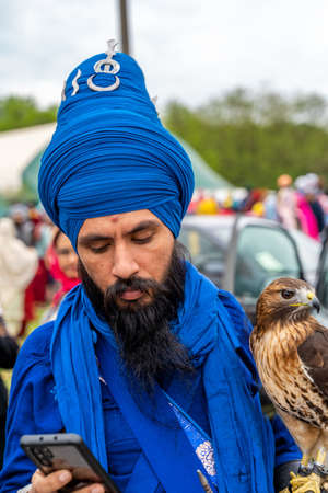 CREMONA, ITALY - APRIL 2022: young bearded warrior of the Sikh monotheism religion in procession with a hawk through the spring festival Vaisakhi in Cremona. The Sikh festival takes place every year.のeditorial素材