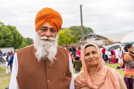 CREMONA, ITALY - APRIL 2022: mature couple of the Sikh monotheism religion in procession through the spring festival Vaisakhi in Cremona. The Sikh festival takes place every year.のeditorial素材
