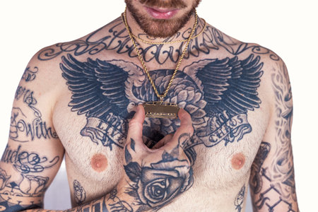 tattooed rap singer posing in studio shirtless on a white backgroundの写真素材