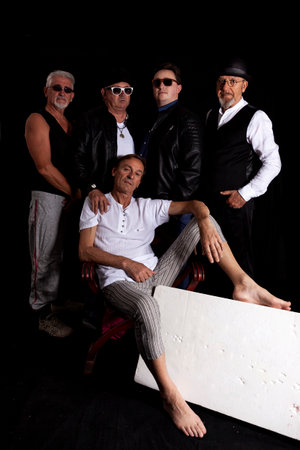 group of mature hipster dressed casual clothing in a photo studio on a black background