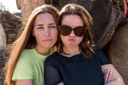 couple of pretty friendly women taking a selfie making funny faces