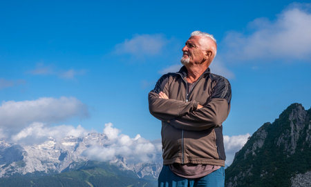 portrait of middle aged man hiker on top of european mountain range - summer vacation conceptの写真素材