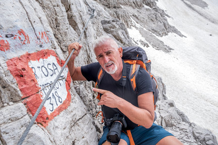 portrait of middle aged man hiker on top of european mountain range - summer vacation conceptの写真素材