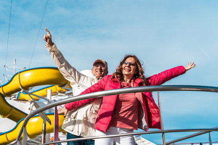 beautiful happy middle aged couple having fun on the deck of a cruise ship - travel and vacation conceptの写真素材