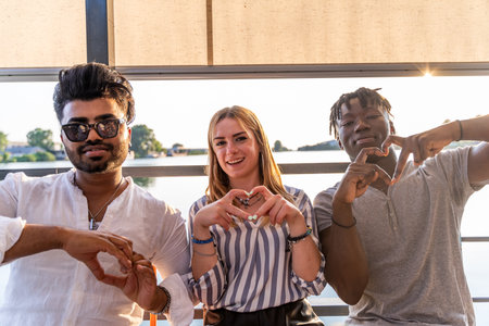 small group of young adult multiethnic friends showing heart sign with hands - summer vacation concept on a ship on the riverの写真素材