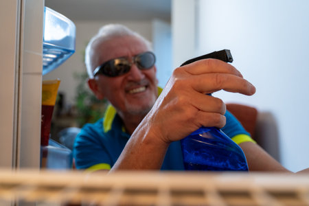 middle aged single man cleaning the fridge cheerfully - view from inside the home appliance