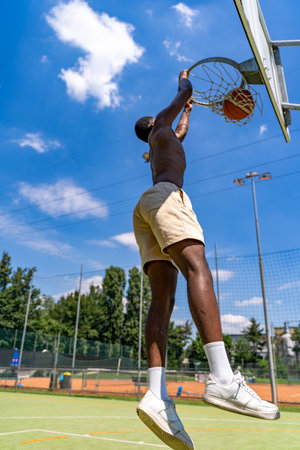 young african american basketball player athlete in action jumping on artificial turf playing field...