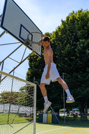 young caucasian basketball player athlete in action jumping on artificial turf playing field on a...