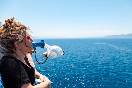 blonde woman enjoying the trip on a cruise ship looking at the sea