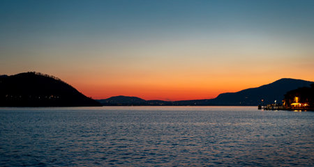 beautiful sunset view on the blue waters of lake with the mountain range in the background on a winter dayの写真素材