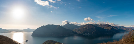 beautiful aerial view of the blue waters of lake iseo with the mountain range in the background on a sunny winter dayの写真素材