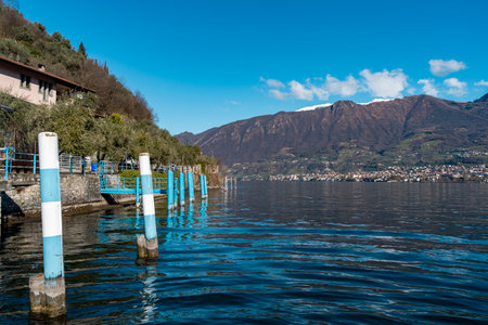 beautiful view of the pier of a small tourist port on the blue waters with the mountains in the backgroundの写真素材