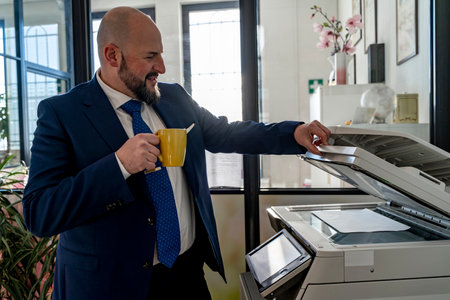 businessman activating laser printer to scan a document in a modern officeの写真素材