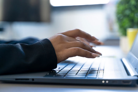 close up of female hands of a businesswoman typing on a laptop keyboard in an officeの写真素材