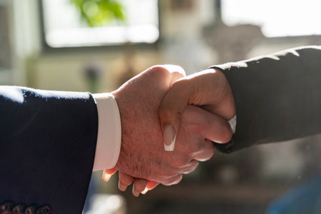 close up on handshake between a businessman and a businesswoman in a modern officeの写真素材