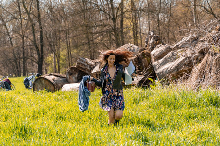 red-haired woman running in a grassy field with watercolor paint kitの写真素材