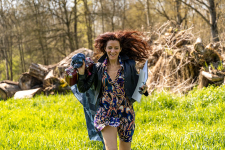 red-haired woman running in a grassy field with watercolor paint kitの写真素材