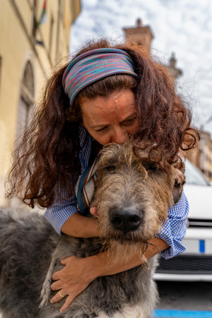 Woman embracing and showing affection to an irish wolfhound dog outdoors