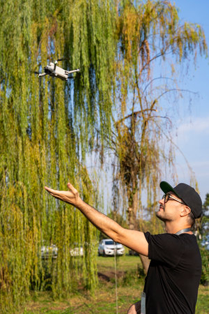 Pilot launching small drone from hand in outdoor setting